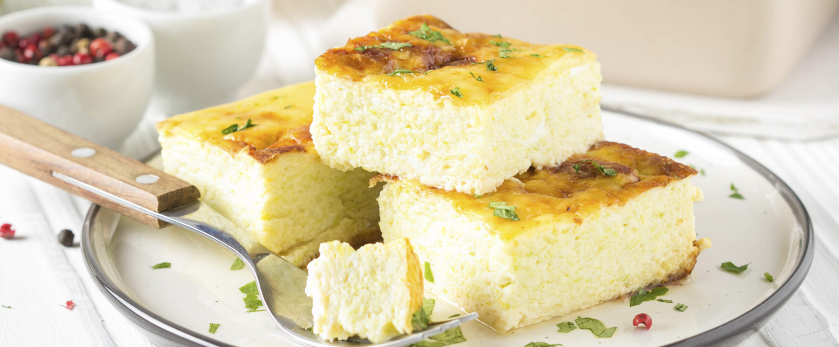 Une omelette moelleuse et dorée, garnie d'herbes, servie avec des toasts sur la table du petit-déjeuner.