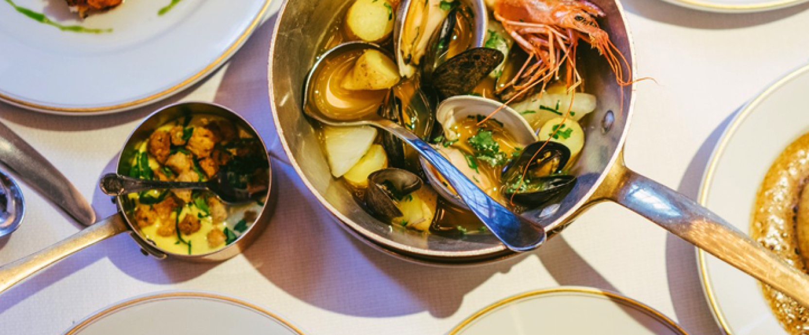 Une image représentant la cuisine française : baguettes, fromages, vins et gastronomie.